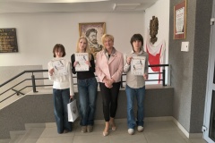 Uczeń i 2 uczennice z Panią dyrektor z dyplomami na tle obrazu przedstawiającego patrona szkoły